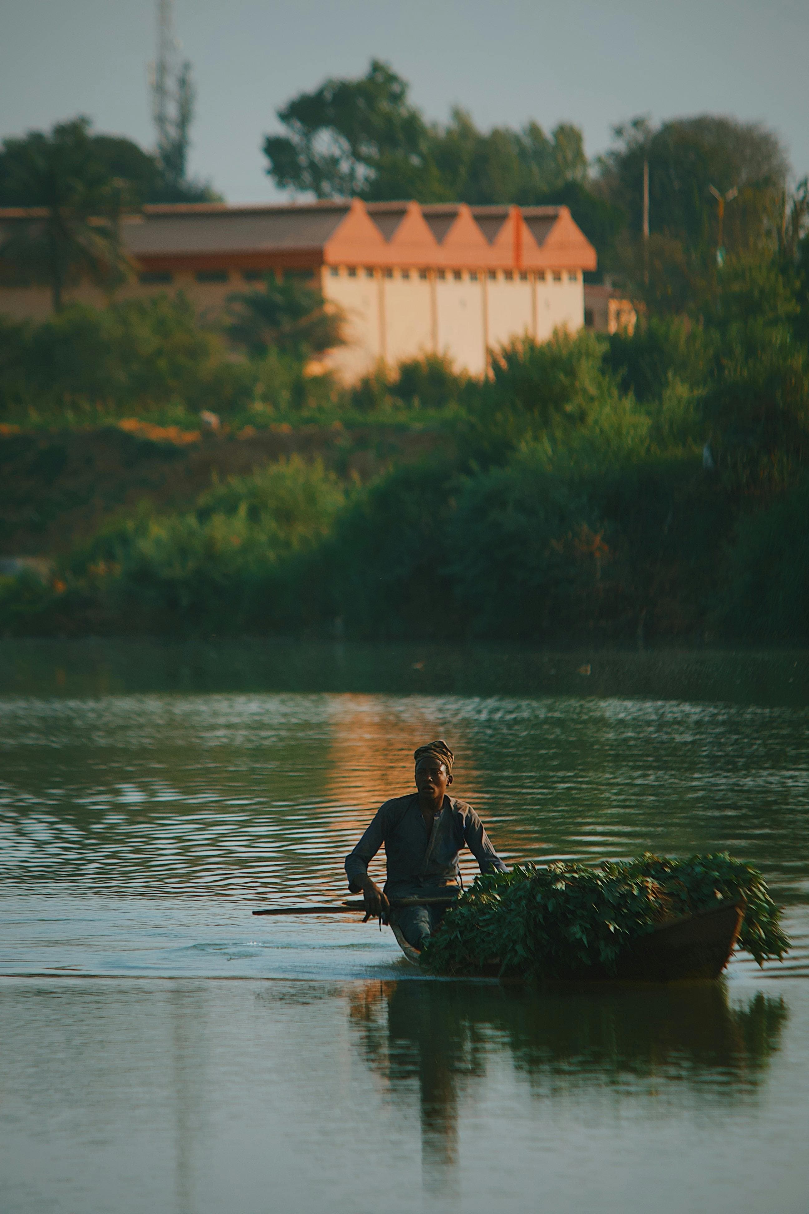 Homme en pirogue sur le fleuve Gambie au coucher du soleil